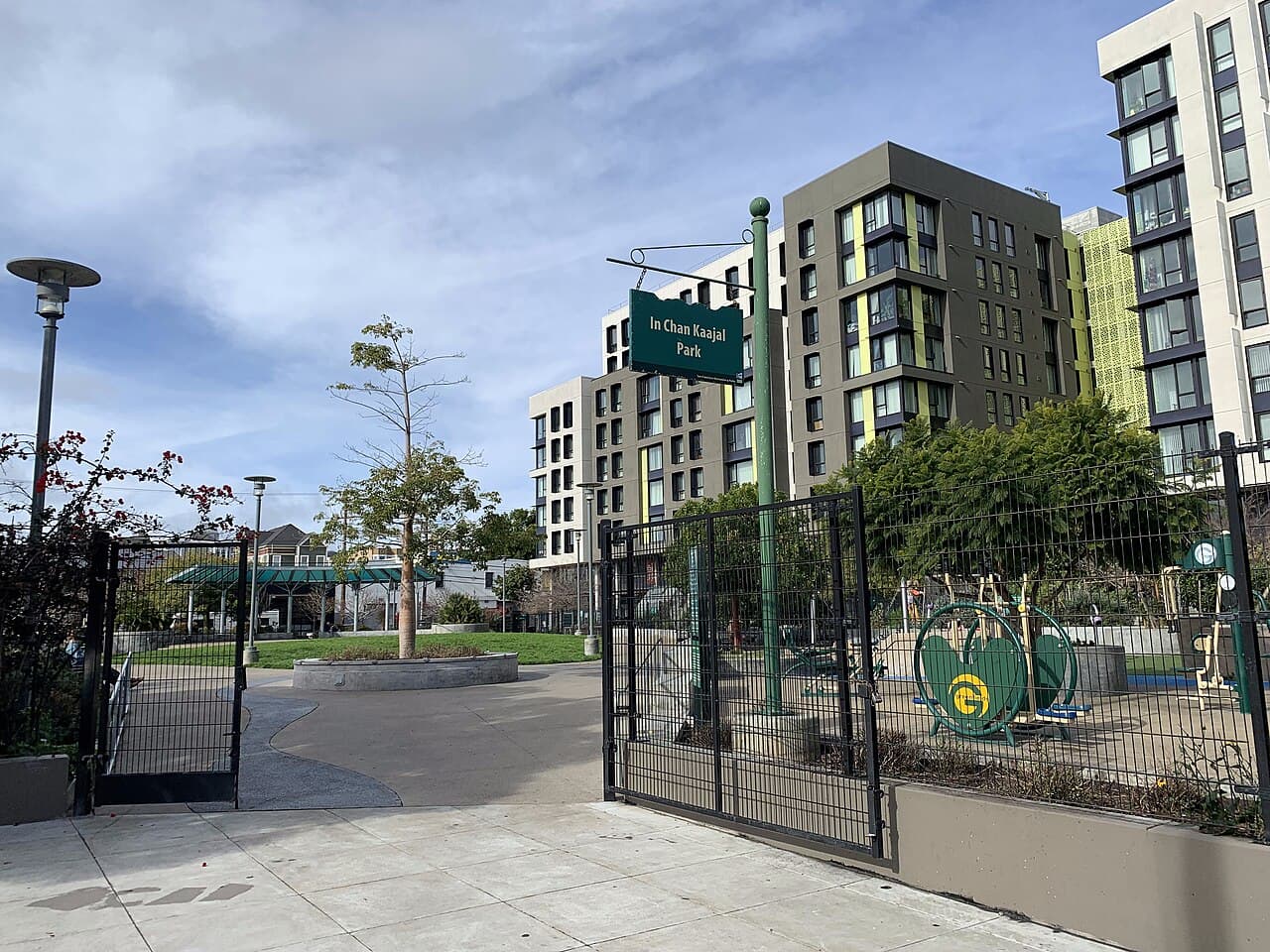 The Folsom Street entrance to In Chan Kaajal Park, with paths and play areas beyond the gates